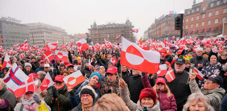 Manifestantes ondean banderas de Groenlandia mientras participan en una manifestación bajo los lemas "manos fuera de Groenlandia" y "Groenlandia para los groenlandeses", frente al Ayuntamiento de Copenhague, Dinamarca, el 17 de enero de 2026.