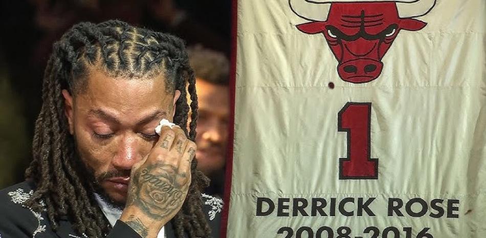 Derrick Rose exbase de los Bulls se seca las lágrimas tras estar junto a su camiseta retirada por los Bulls de Chicago.