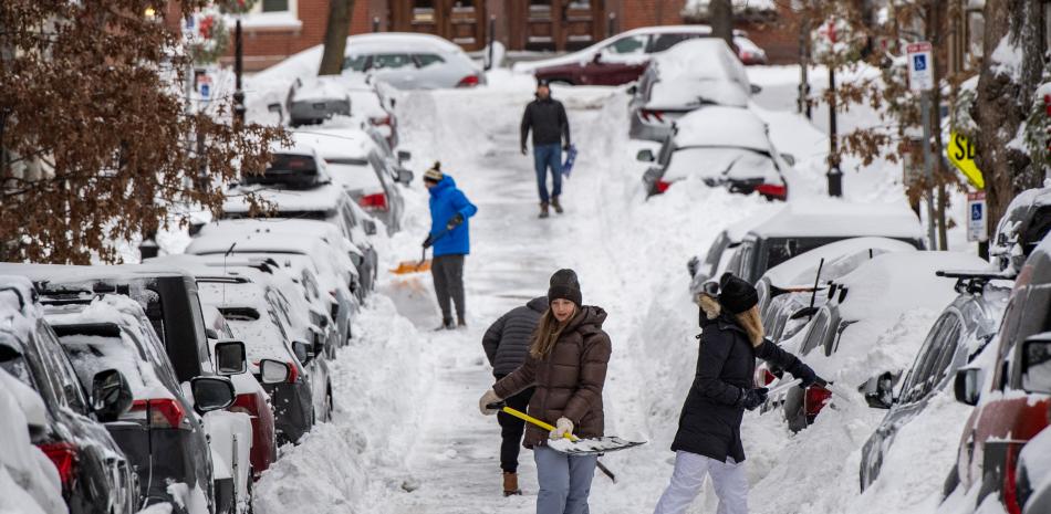 Personas palean nieve en una calle residencial del barrio de Charlestown en Boston, Massachusetts, el 26 de enero de 2026.