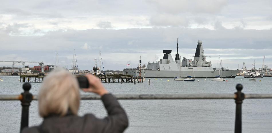 Un miembro del público fotografía al HMS Dragon, un destructor de defensa aér ea de la clase Daring Tipo 45 de la Marina Real Británica, guiado por remolcadores operados por Serco Marine Services desde la Base Naval de Portsmouth, en la costa sur de Inglaterra, el 10 de marzo de 2026.