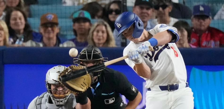 | Will Smith, de Los Angeles Dodgers, a la derecha, conecta un jonrón de dos carreras mientras el receptor de los Arizona Diamondbacks, James McCann, observa durante la octava entrada del encuentro.