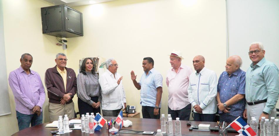 El doctor Dionisio Guzmán, Presidente del Pabellón de la Fama, toma el juramento al periodista y abogado José P. Monegro. Los acompañan, desde la izquierda, Rolando Guante, Rafael Villalona, Niurca Herrera, José Rodríguez Conde, Juan Niemen, Rafael Damiron y Alejandro Bello Ferreras.
