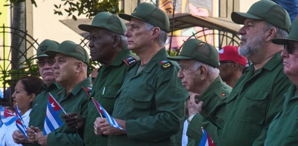 El presidente cubano Miguel Díaz-Canel, en el centro, asiste a una celebración conmemorativa del 65 aniversario de la proclamación que declara socialista a la revolución cubana.