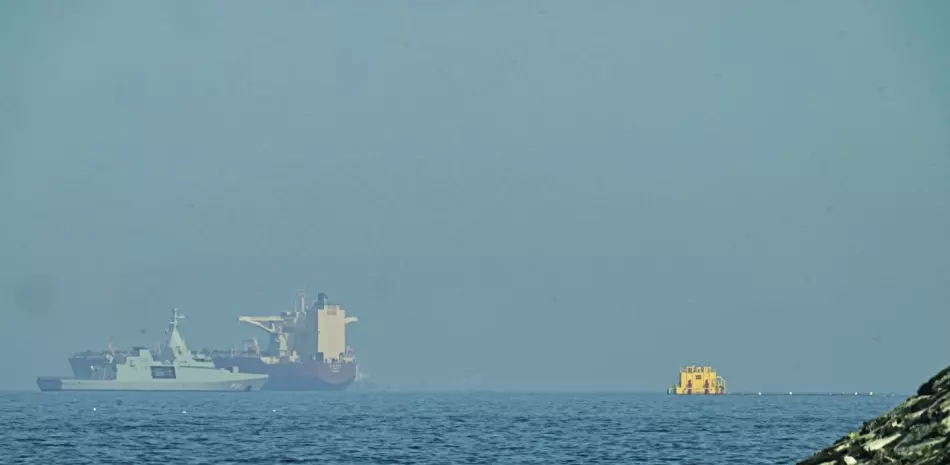 Una patrullera emiratí, izquierda, navega cerca de un petrolero fondeado en el golfo de Omán, cerca del estrecho de Ormuz, vistos desde una carretera costera cerca de Khor Fakkan, Emiratos Árabes unidos, el 1 de mayo de 2026.