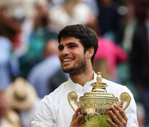 Carlos Alcaraz sostiene el trofeo de ganador tras vencer a Novak Djokovic en la final individual masculino de Wimbledon el 16 de julio de 2023