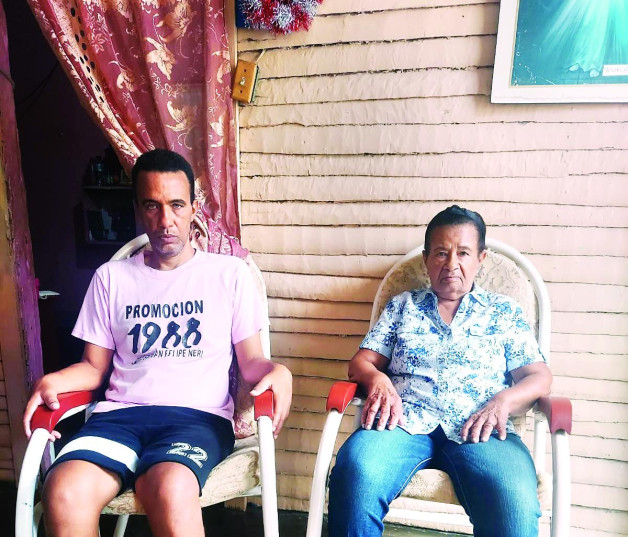 Margarita Reina González Lachapel y su hijo, sentados en su casa situada en el barrio Villa Meja, en Baní.