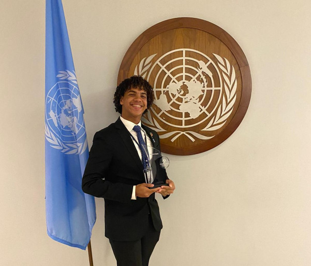 Fotografía muestra al joven Jasuer Alberto Ortiz Santos, estudiante en el Centro Educativo Mayajé, en la sede de la Organización de las Naciones Unidas (ONU), sonríe con su estatuilla del premio.