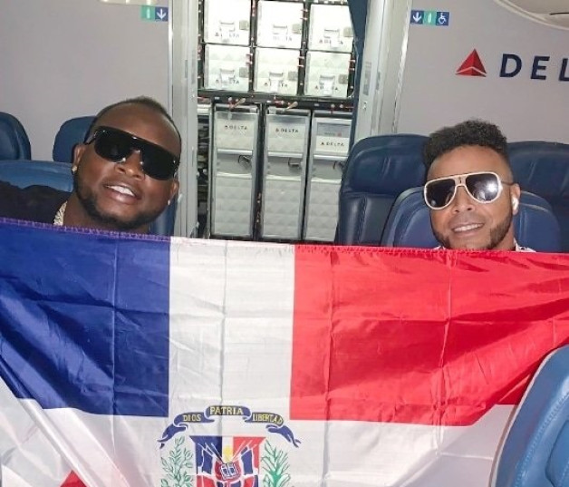Nelson Cruz y Miguel Ángel Sanó mostrando la bandera dominicana en pleno vuelo.