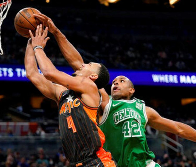 Al Horford, de los Celtics, realiza una gestión defensiva frente a Jalen Suggs, de los Magic, en acción del partido del domingo por la noche en la NBA.