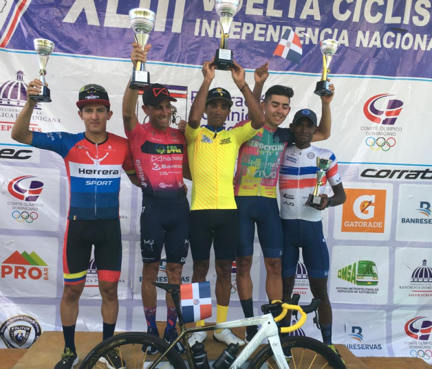 Ismael Sánchez, al centro, levanta el trofeo de campeón de la Vuelta Ciclista Independencia Nacional.