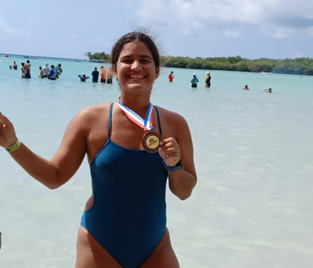 La triatleta Laura Amelia Batller posa con su medalla de oro obtenida en el XII Boca Chica Open Water, auspiciado por el INEFI.