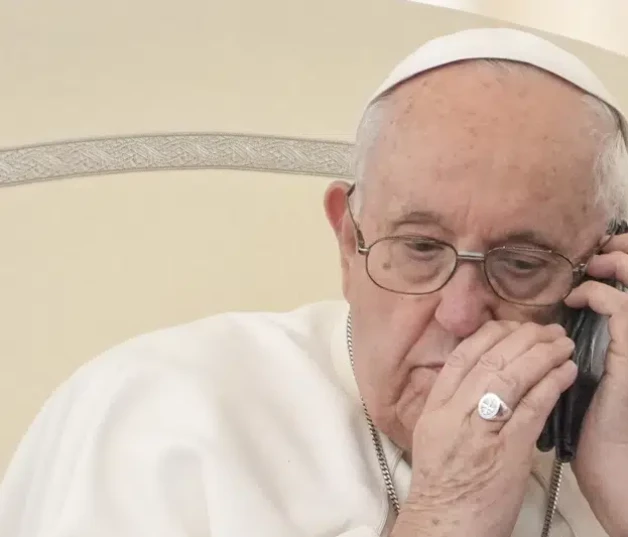 El papa Francisco habla por teléfono en la audiencia en la Plaza San Pedro del Vaticano ayer.