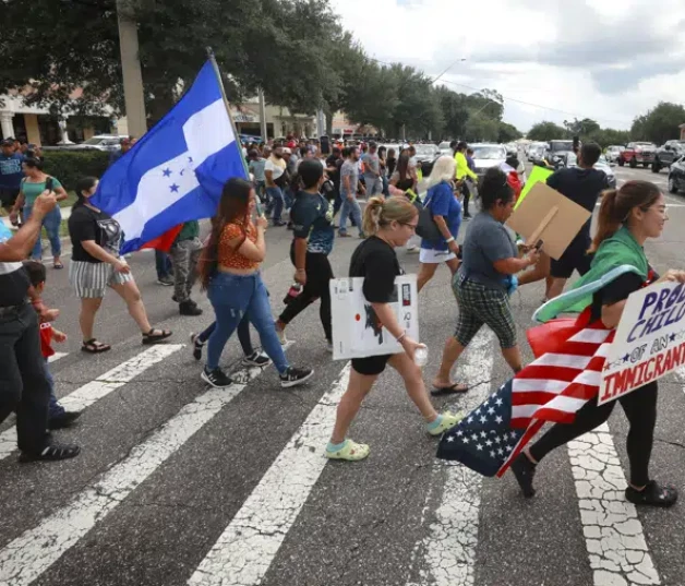 Manifestantes cruzan una calle, ayer jueves, en Orlando, Florida, durante una protesta contra la nueva ley de inmigración de Florida que promulgó el gobernador Ron DeSantis.