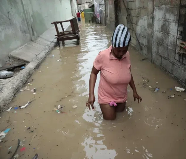 Una mujer camina por una zona inundada luego de las lluvias registradas en Puerto Príncile, el sábado pasado.