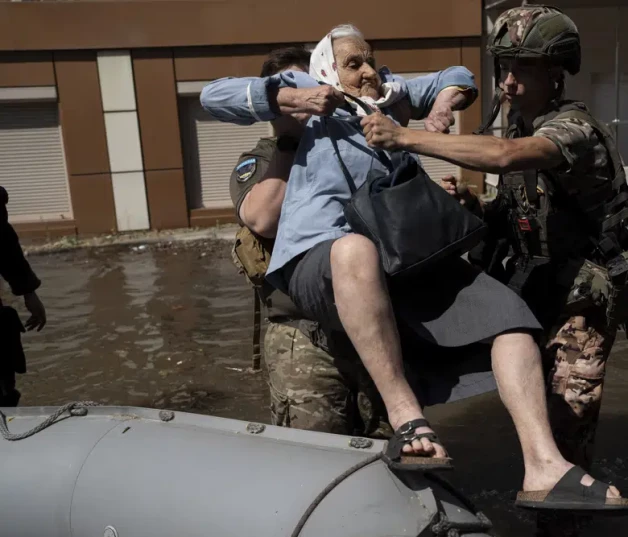 Una mujer es evacuada de un vecindario inundado en Jersón, Ucrania, ayer, tras la rotura de la represa de Kajovka.