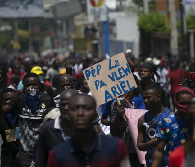 Un hombre sostiene un letrero con el mensaje "La gente no te quiere Ariel", durante una protesta por la renuncia de Ariel Henry, en Puerto Príncipe, el 7 de septiembre de 2022.