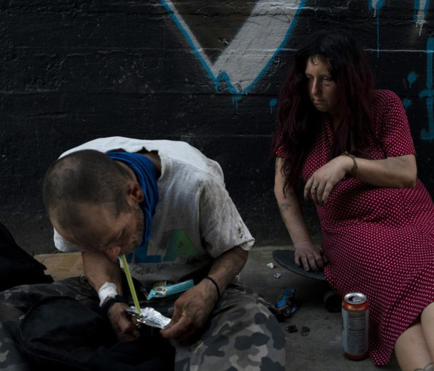 Jenn Bennett, que está drogada con fentanilo, se sienta sobre su patineta con un ojo morado mientras su amigo, Jesse Williams, fuma la droga el martes 9 de agosto de 2022, en Los Ángeles.