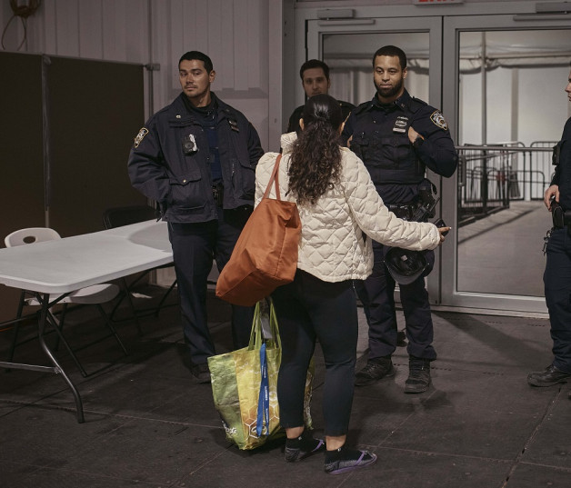 Una migrante habla con la policía en un albergue para migrantes en Randall's Island, el martes 9 de abril de 2024, en Nueva York.