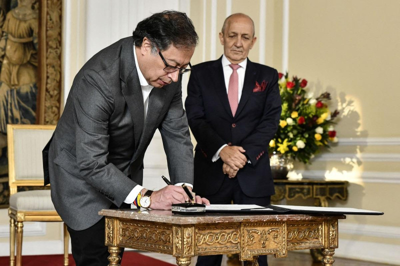 El presidente de Colombia, Gustavo Petro (izquierda), firmando un documento junto al nuevo Consejero de Estado, Jorge Duque (derecha), en Bogotá el 26 de abril de 2023.