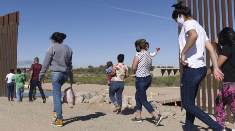 Un grupo de migrantes brasileños cruza por una apertura en la frontera entre Estados Unidos y México, el lunes 8 de junio de 2021.