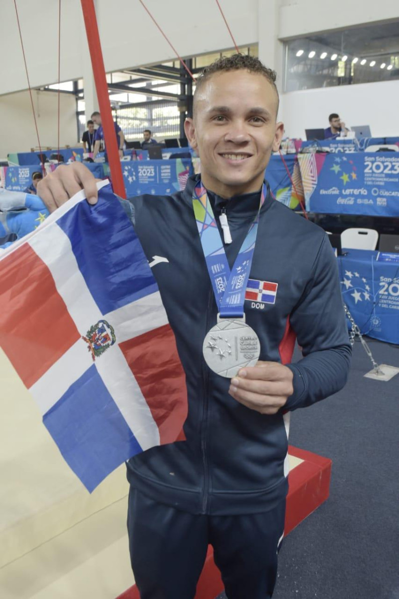 Nin Reyes mostrando su medalla y la bandera dominicana.