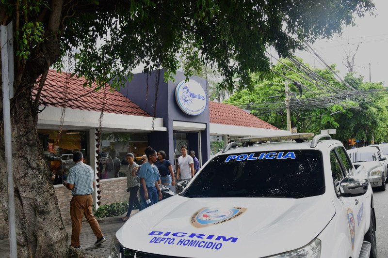 Un vehículo de la Dicrim estacionado en el restaurante Villar Hermanos, ubicado en el sector Gazcue, tras el incidente que ha dejado un hombre herido de bala.