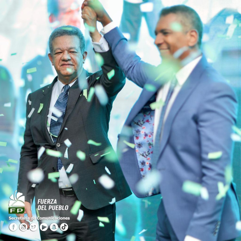 El expresidente Leonel Fernández, candidato presidencial del partido Fuerza del Pueblo, levanta la mano del candfidato a senador por santiago,
