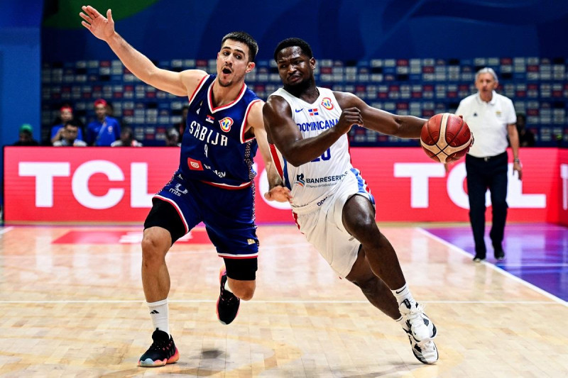 Andrés Feliz, de República Dominicana, trata de superar la defensa del serbio Vanja Marinkovic en el partido de la segunda ronda de la Copa Mundial de Baloncesto.