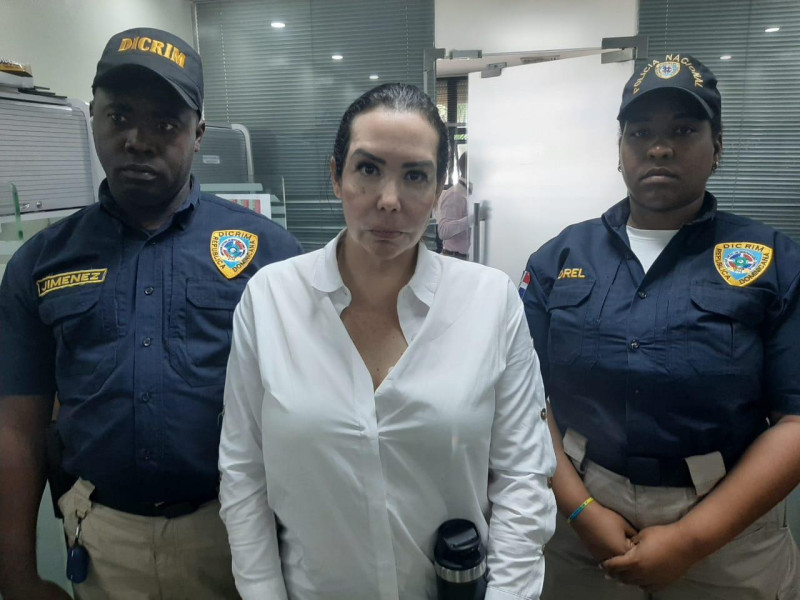 Karla María Moya Boada, la supuesta cirujana plástica de origen venezolano posa junto a dos agentes de la Dirección General de Migración (DGM).