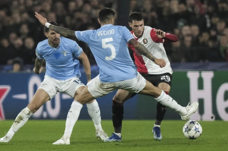 Santiago Giménez, de Feyenoord, elude a Matias Vecino, de Lazio, durante el partido de la Liga de Campeones en el Grupo E en el estadio Feyenoord, en Rotterdam.