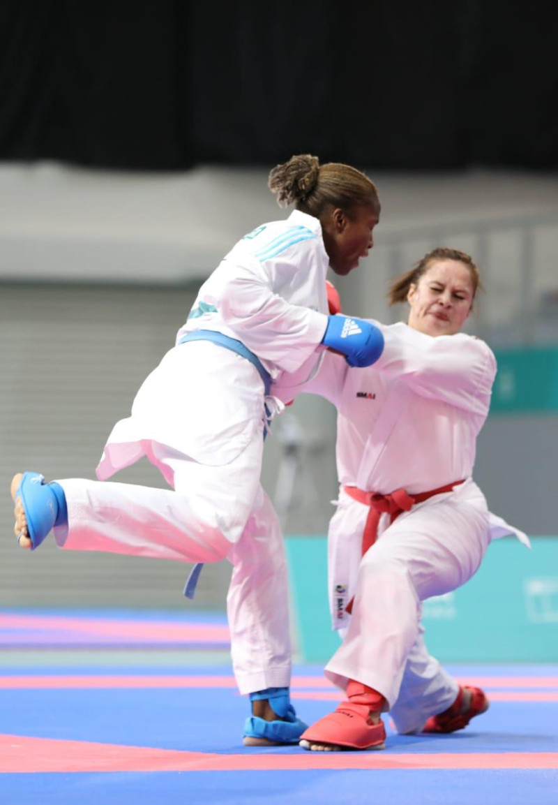La Karateca dominicana Pamela Rodríguez (azul) mientras desataca un ataque a la ecuatoriana Valeria Echever.