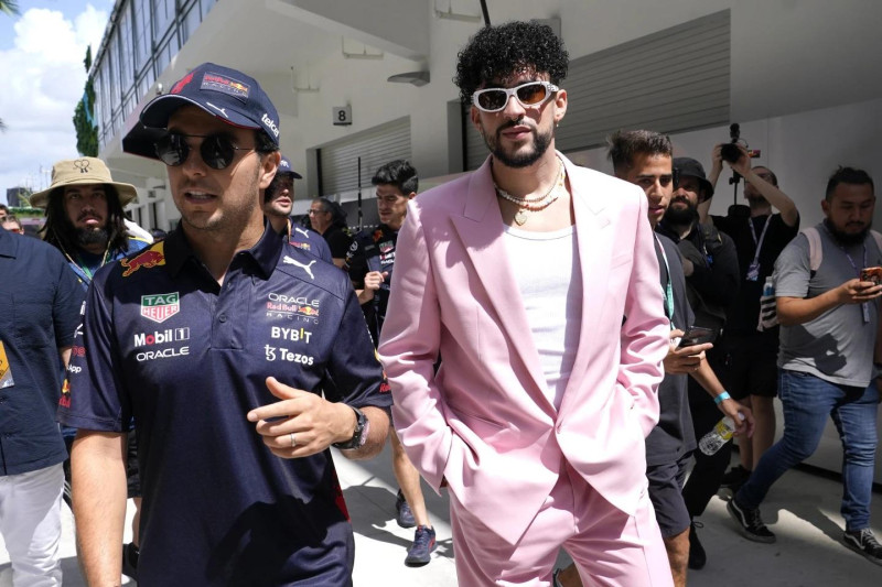 El piloto de Red Bull Sergio Pérez, de México, izquierda, camina con el reggaetonero puertorriqueño Bad Bunny antes del Gran Premio de Fórmula Uno de Miami.