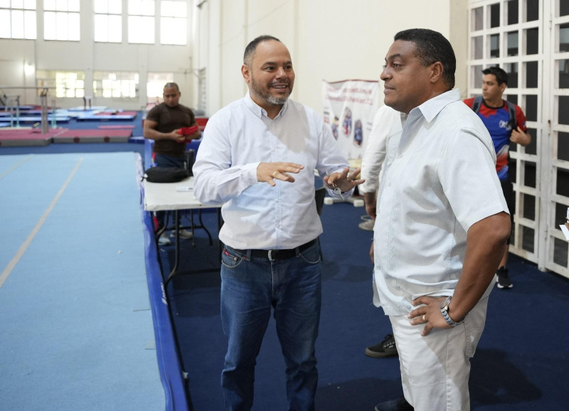 José P. Monegro escucha explicaciones de Edwin Rodríguez, presidente de la Federación Dominicana de Gimnasia.