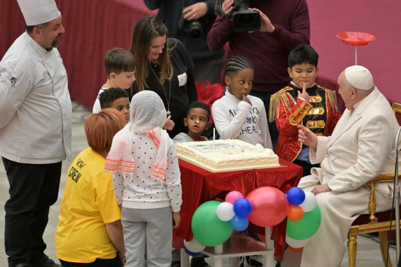 Una tarta de cumpleaños es presentada al Papa Francisco por su 87 cumpleaños durante una audiencia a los niños del dispensario Santa Marta en la sala Pablo-VI