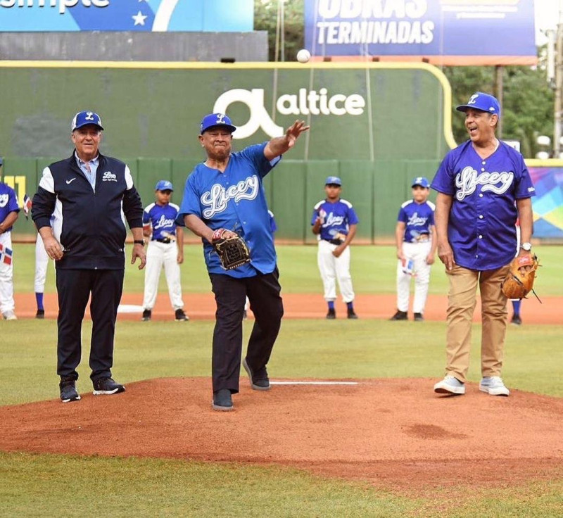 El doctor Rafael Lantigua lanza la primera bola en juego del Licey. Figuran Adriano Espaillat, representante del Distrito 13 en Nueva York, y Miguel Fernández, tesorero.