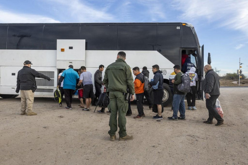 Inmigrantes suben a un autobús del Servicio de Aduanas y Protección de Fronteras de Estados Unidos tras cruzar la frontera entre México y Estados Unidos el 7 de enero de 2024 en Eagle Pass, Texas