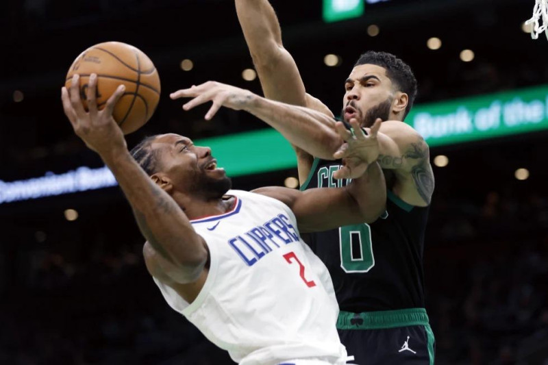 Kawhi Leonard (2) de los Clippers, lanza ante Jayson Tatum (0) de los Celtics de Boston, durante la primera mitad del juego de baloncesto de la NBA en Boston.
