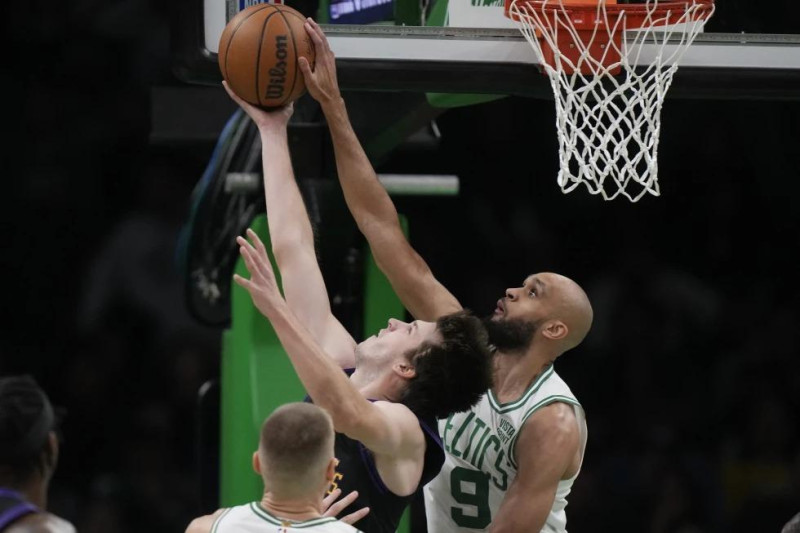 Austin Reeves, de los Lakers, recibe un bloqueo por parte de Derrick White, de los Celtics, en el partido del jueves en el baloncesto de la NBA.
