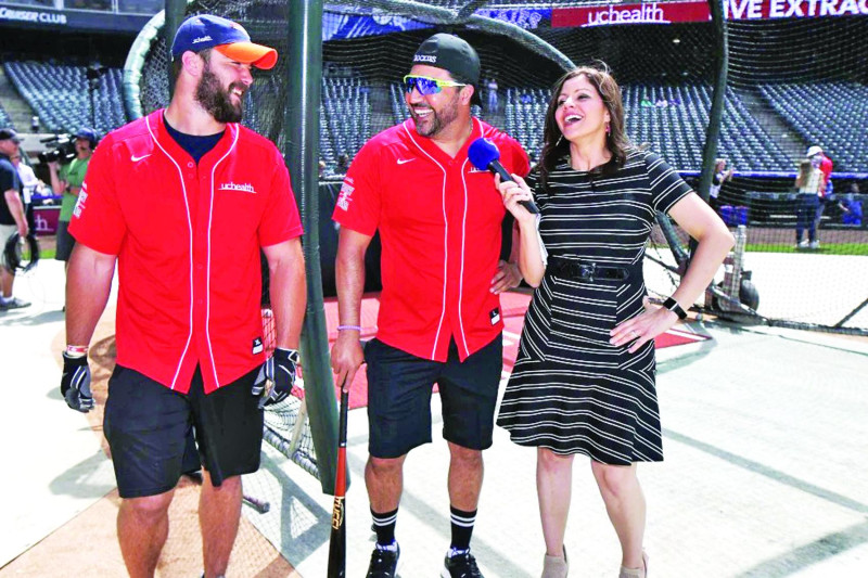 La locutora de televisión de los Rockies de Colorado, Jenny Cavnar, derecha, bromea con Vinny Castilla, centro, asistente especial del gerente general de los Rockies, y el fullback de los Broncos de Denver, Andy Janovich.