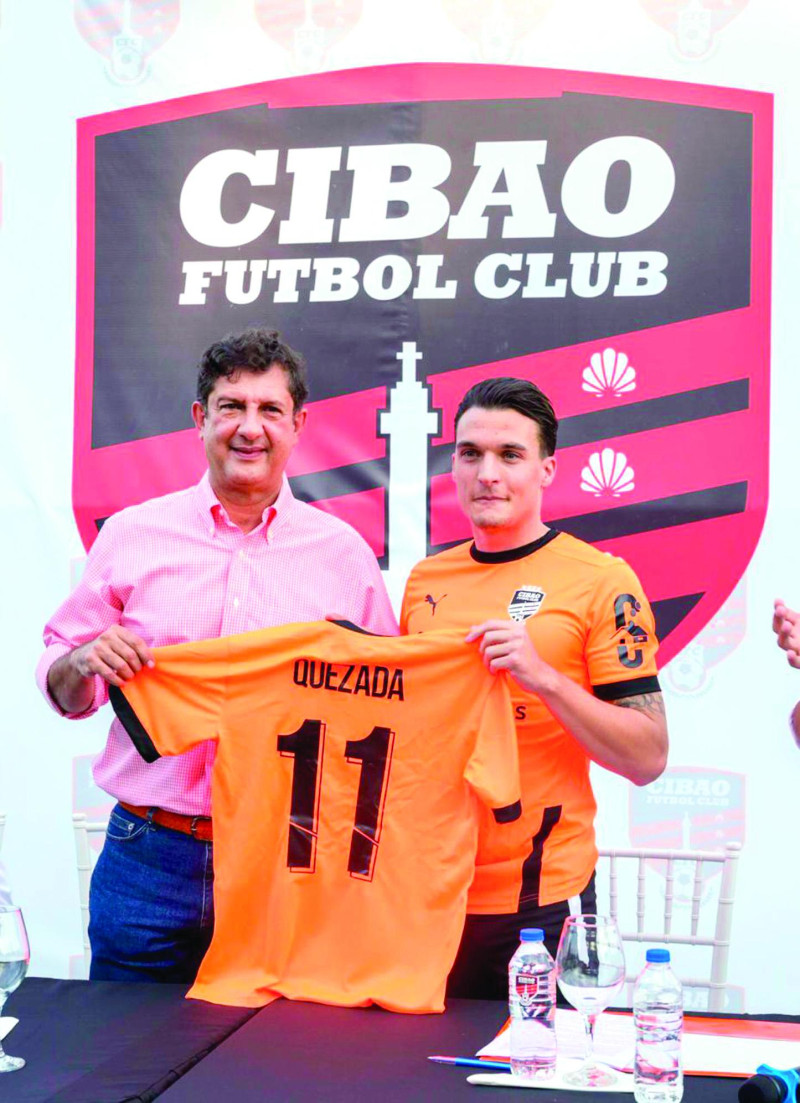 Manuel Estrella, presidente del Cibao FC, entrega la camiseta a Luismi Quezada, el nuevo integrante de los campeones de la Liga Dominicana de Fútbol.