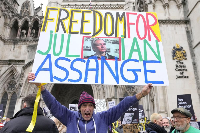 Manifestantes alzan carteles con la leyenda "libertad a Julian Assange" frente a los tribunales de Londres, martes 20 de febrero de 2024.