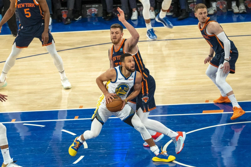 Stephen Curry, de los Warriors, busca ir hacia el canasto ante la defensa de Isaiah Hartenstein, de los Knicks, en el partido de la NBA.