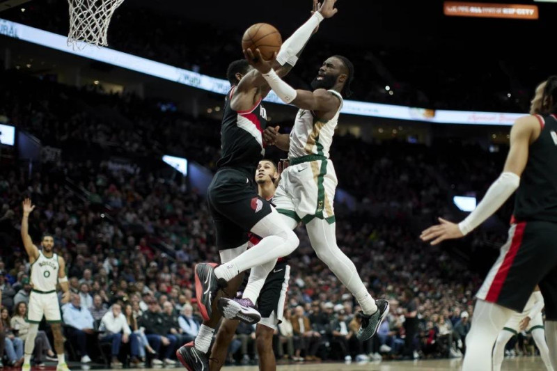 Jaylen Brown, de los Celtics de Boston, intenta una canasta sobre Deandre Ayton, de los Trail Blazers de Portland, durante la primera mitad del juego de la NBA.