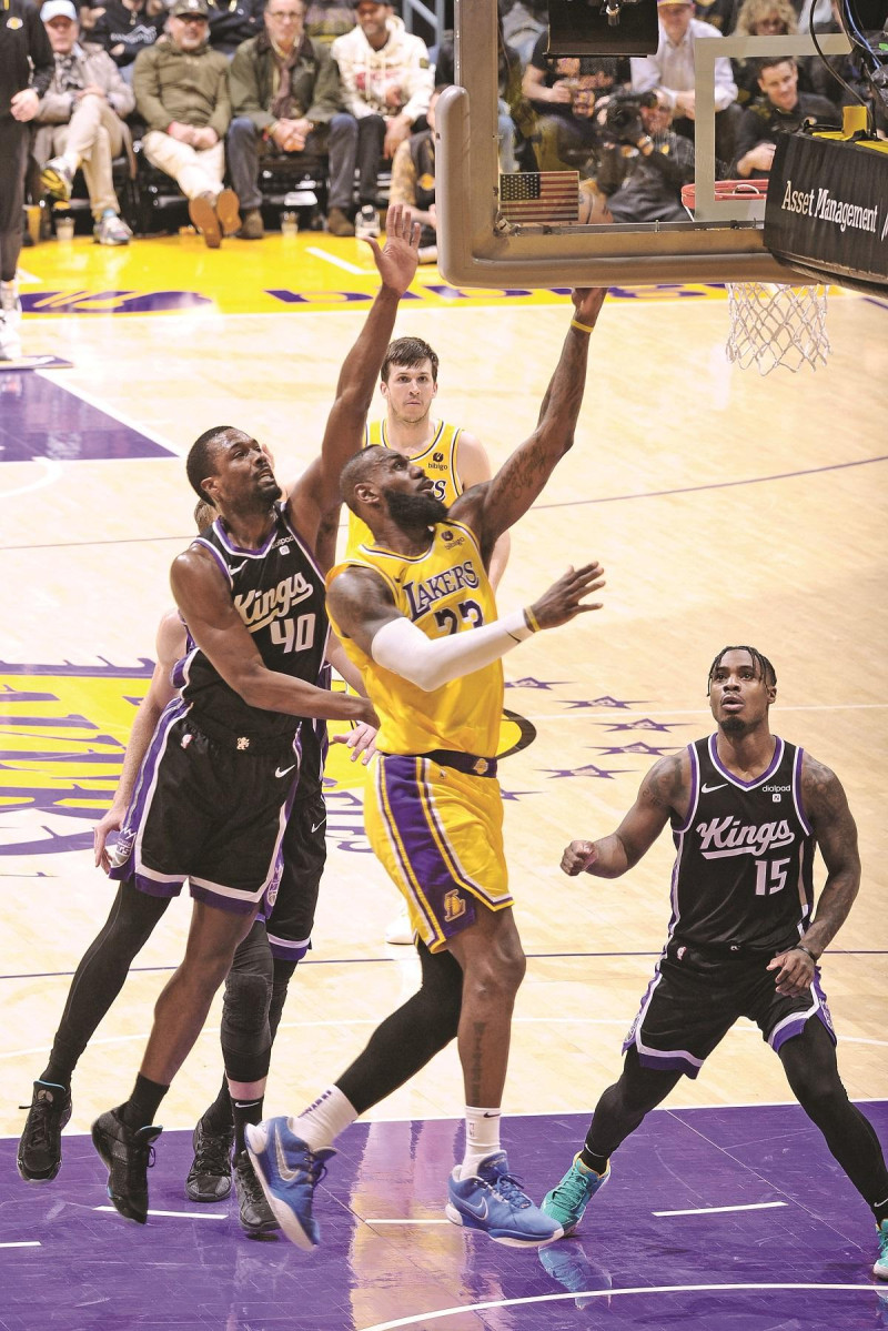 LeBron James, de los Lakers de Los Angeles, encesta un canasto ante la defensa de Harrison Barnes, de los Kings de Sacramento.