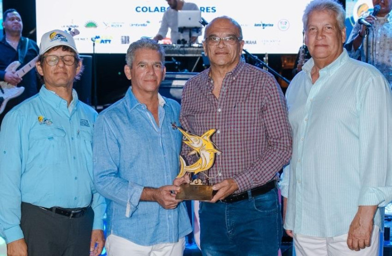 El comodoro del CNSD, Battésimo Palamara, junto al past comodoro José Luis Núñez y el director del torneo al pez Dorado, Max Rodríguez, entregan el reconocimiento a Torres Ocumárez.