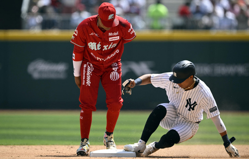 New York Yankees' Osvaldo Cabrera (R) touches the second base next to Mexico's Diablos Rojos Robinson Cano (L) during the first inning of the first exhibition baseball game at the Alfredo Harp Helu stadium in Mexico City on March 24, 2024.