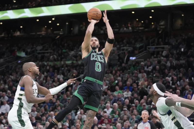 El alero de los Celtics Jayson Tatum lanza el balón frente al alero de los Bucks Khris Middleton en el encuentro de la NBA del miércoles 20 de marzo del 2024.
