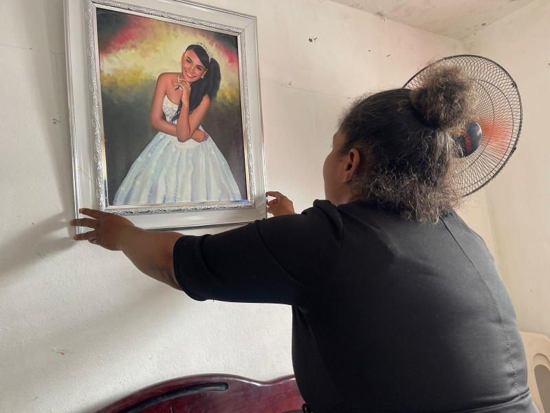 Yenny Hilario, madre de Yanneli, sostiene una foto de su hija en su residencia