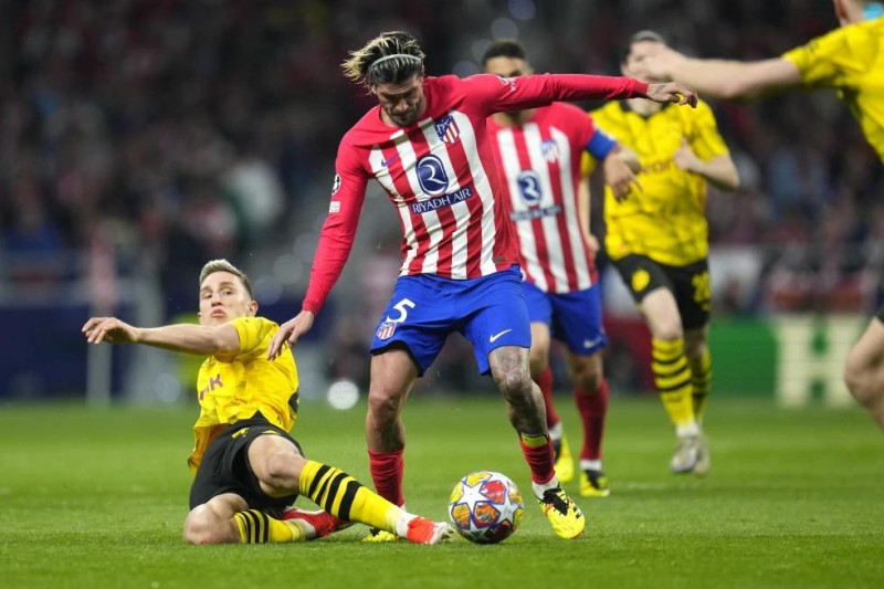 Rodrigo De Paul (centro) del Atlético de Madrid pugna por el balón con Nico Schlotterbeck del Borussia Dortmund en los cuartos de final de la Liga de Campeones.