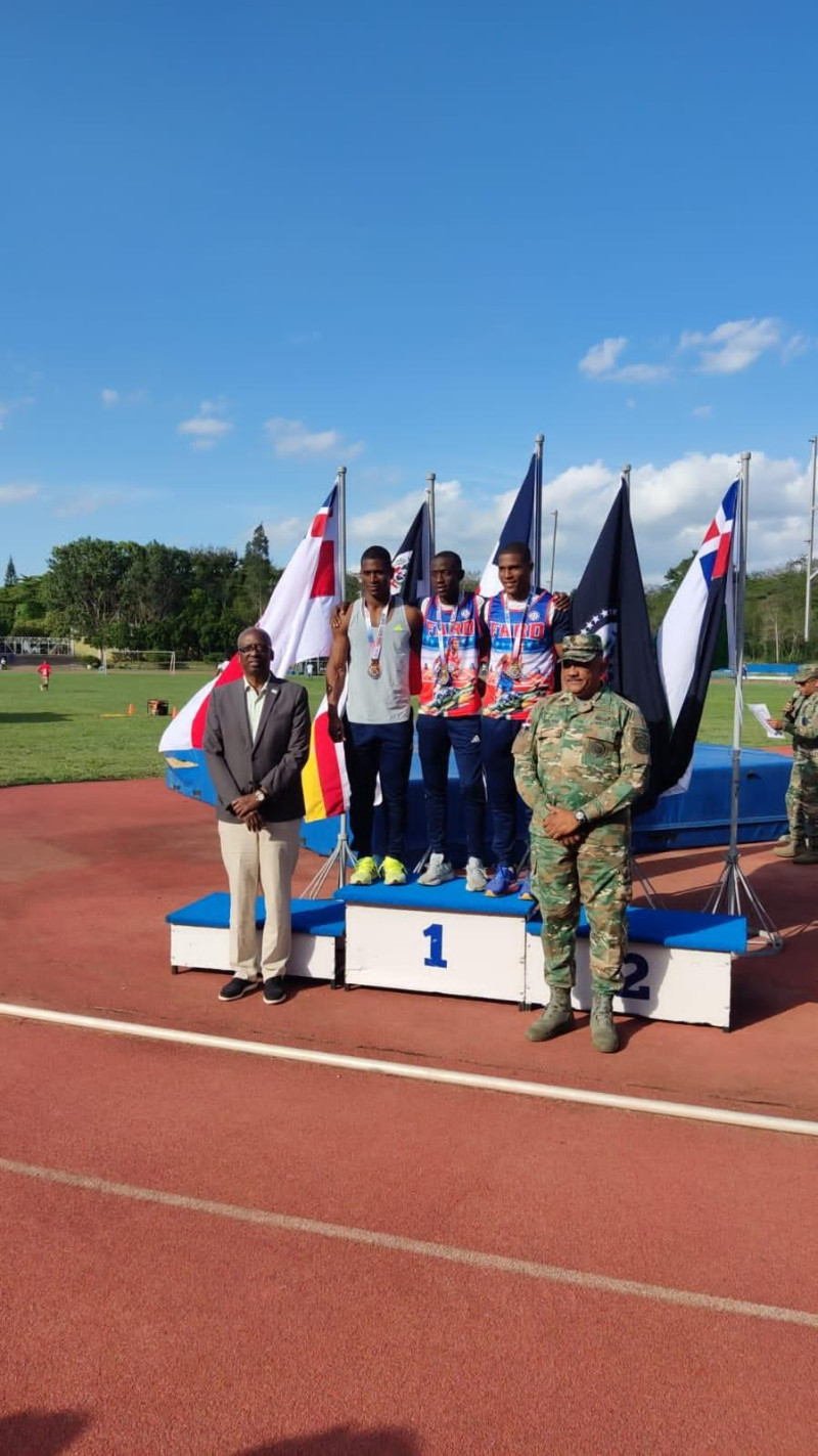 Gerardo Suero Correa y el general Reynoso Green, del Ejército de la República Dominicana, premian a los medallistas en la modalidad de los 100 metros masculinos.